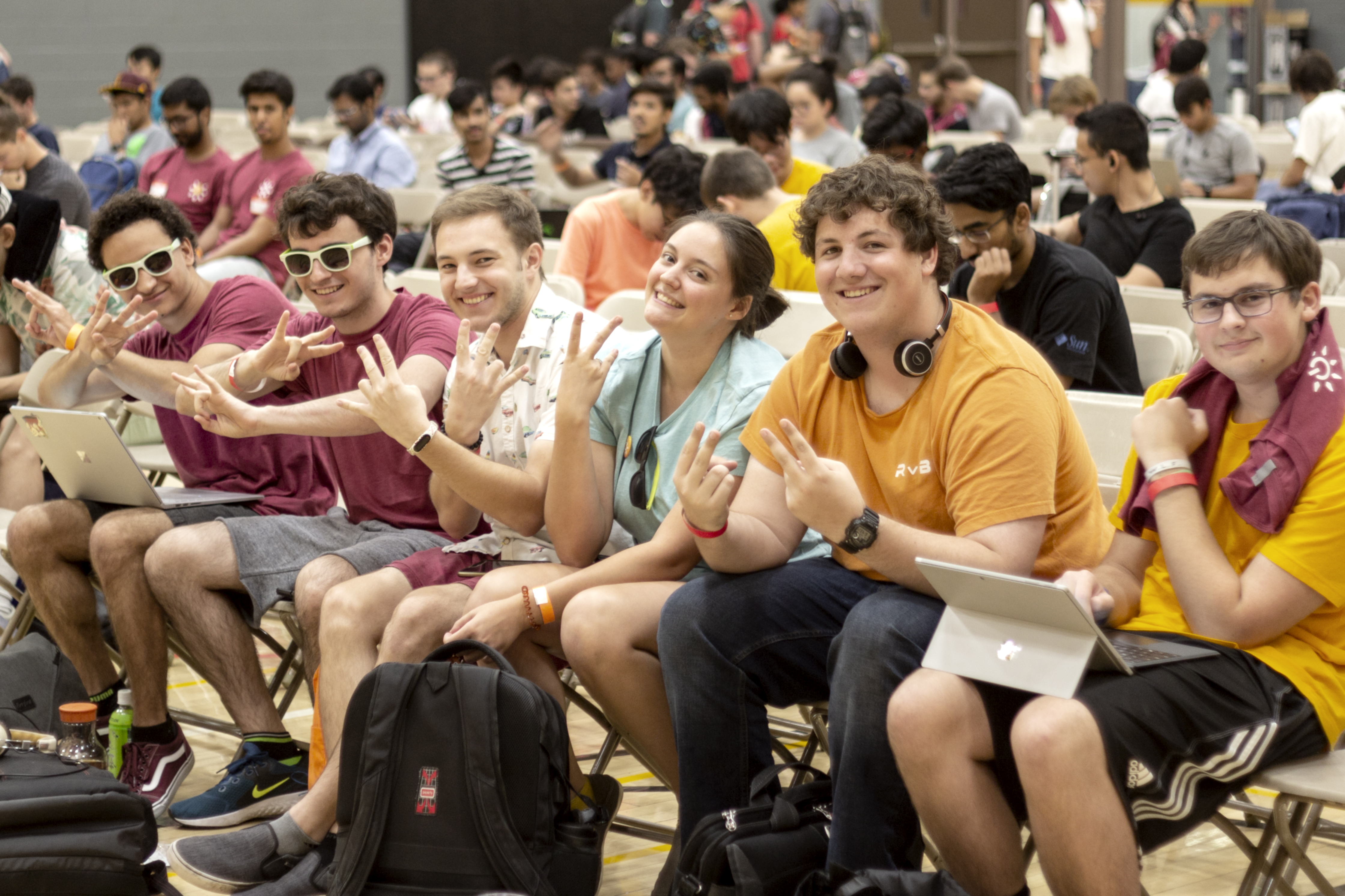 A group of students holding up pitchfork gestures at sunhacks opening ceremonies